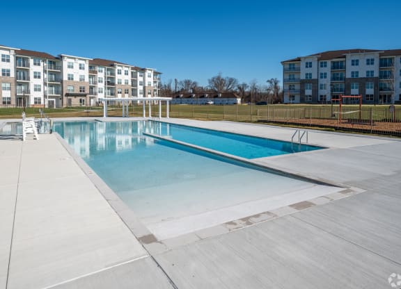 a swimming pool with an apartment building in the background at Fairmont at South Lake, Bowie, Maryland