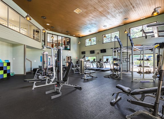A gym with a variety of equipment including treadmills, weights, and exercise machines at Crestline Cary, Cary North Carolina