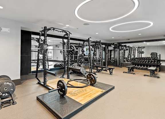 A gym with a variety of equipment including weights and machines.