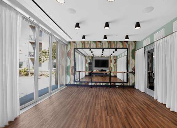 A room with a wooden floor and a striped wallpapered wall.