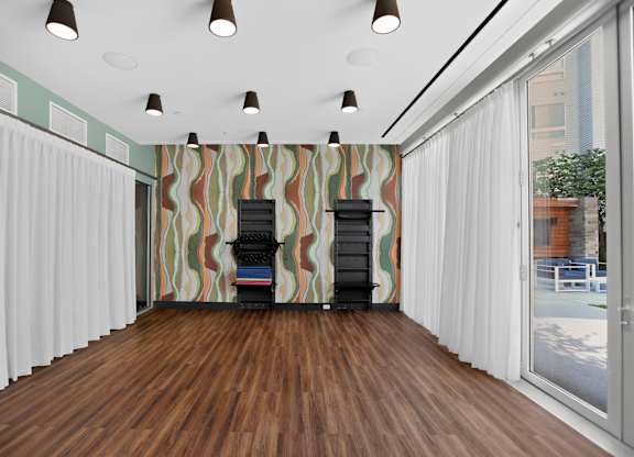 A room with a wooden floor and a striped wallpaper.