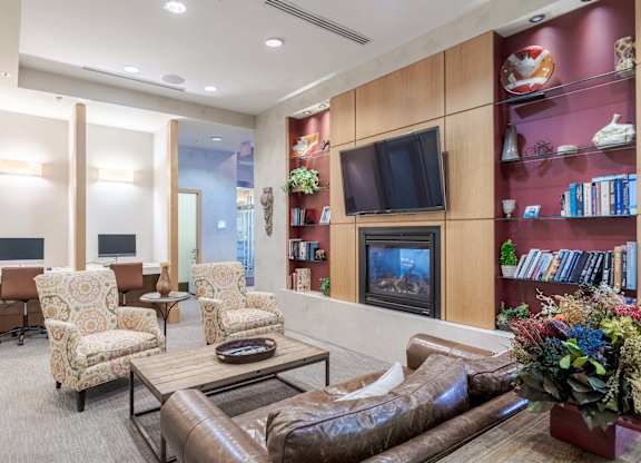 A living room with a brown leather couch, a coffee table, and a television at Garfield Park, Arlington, 22201