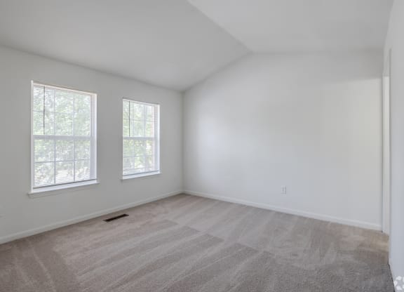 the living room of a home with white walls and carpet at Greens at Stonecreek, Lithonia, Georgia