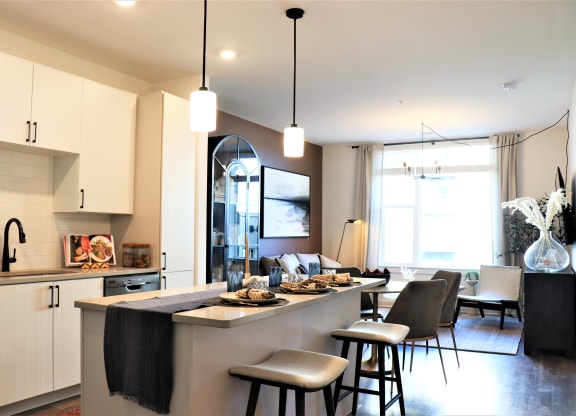 a kitchen with an island and stools in a 555 waverly unit at Vyne One Loudoun, Ashburn, 20147