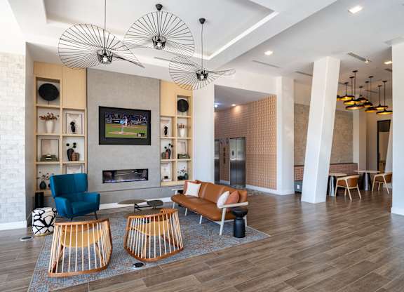 A living room with a television, a fireplace, and a blue chair.