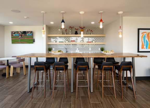 A bar area with a long wooden table and chairs.