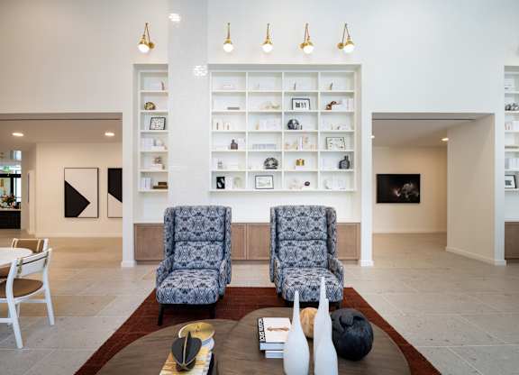 Two chairs sit on a rug in front of a wall of shelves at The Sully Apartments, Chantilly, Virginia