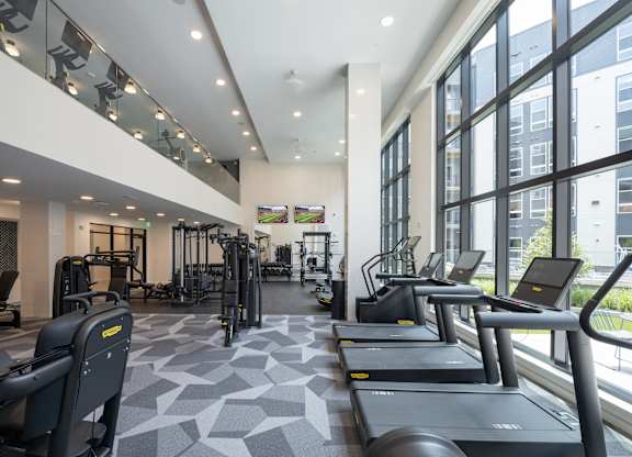 A gym with treadmills, weights, and exercise equipment at The Sully Apartments, Chantilly