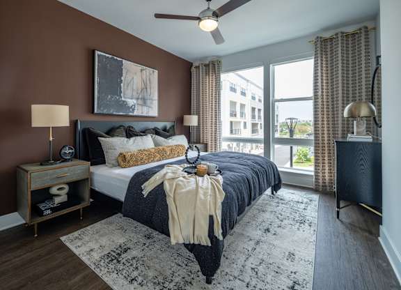 A bedroom with a bed, a ceiling fan, and a window with curtains at The Sully Apartments, Chantilly 20151
