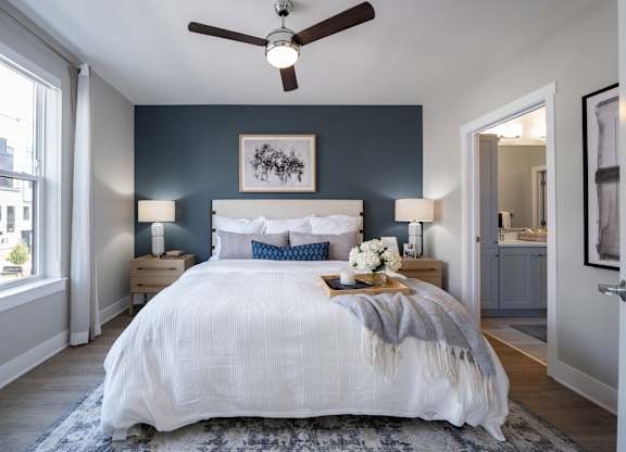 A bedroom with a large bed and a ceiling fan at The Sully Apartments, Chantilly, VA