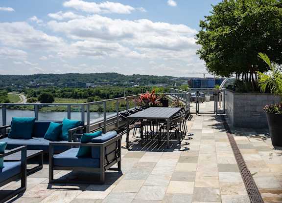 A patio with tables and chairs overlooking a river. at Dock 79, District of Columbia, 20003