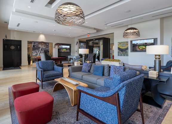 A living room with a blue sofa and a red ottoman. at Dock 79, Washington, DC