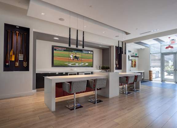 Modern room with a bar and a television playing a baseball game. at Dock 79, Washington, DC 20003 