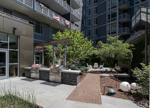 A patio area with a table and chairs is surrounded by apartment buildings. at Dock 79, Washington, DC