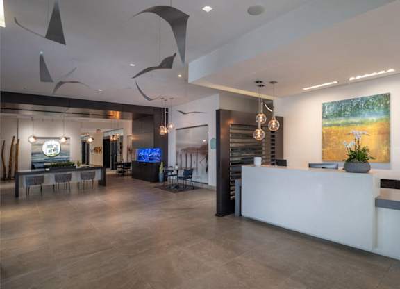 A reception area with a white counter and a large painting on the wall. at Dock 79, Washington, 20003