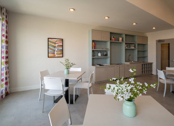 a room with a table and chairs and a kitchen in the background  at Woodmore Grand, Bowie, MD, 20721