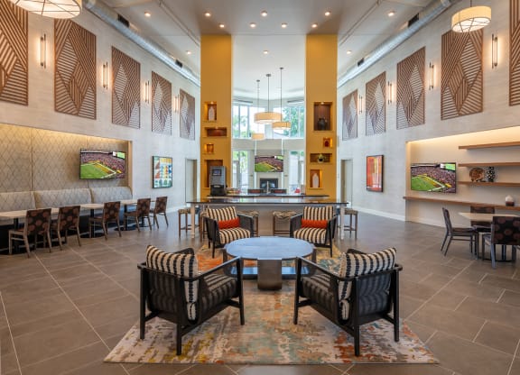 a seating area with tables and chairs in the atrium of a building  at Woodmore Grand, Bowie