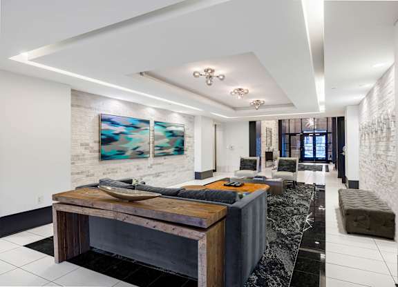 A modern living room with a wooden coffee table and a painting on the wall.