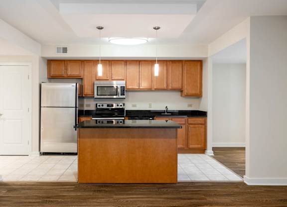 A kitchen with wooden cabinets and a black countertop.