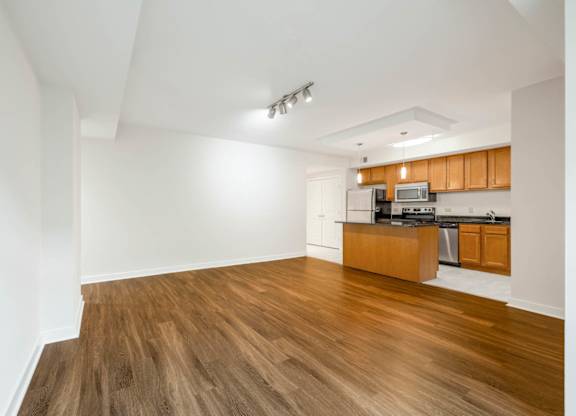 A kitchen with wooden floors and white walls.