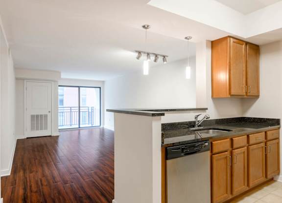 A kitchen with wooden cabinets and a black countertop.