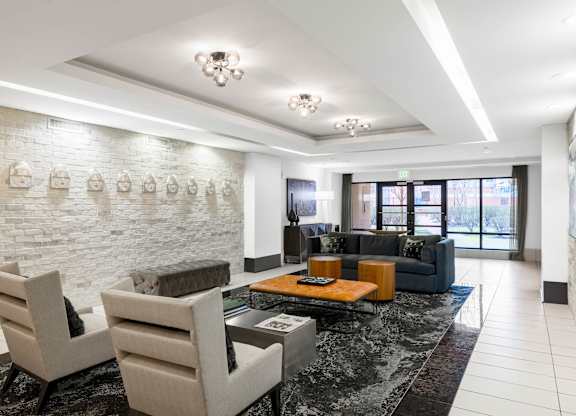 Two chairs and a table are in a room with a white brick wall.