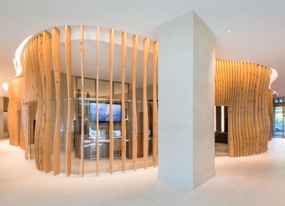 a large white pillar in the middle of a room with a wooden wall behind it and a at The Acadia at Metropolitan Park, Arlington