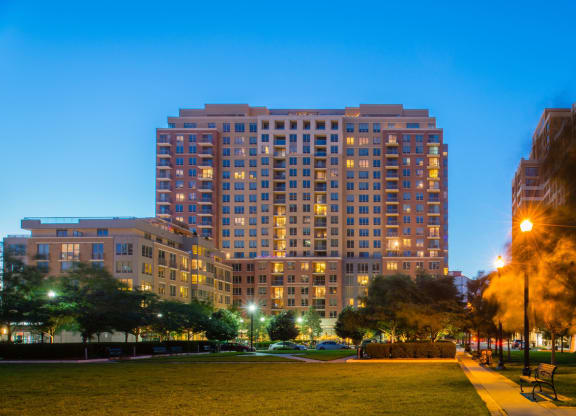 a tall building with many windows and a grassy area in front of it at The Acadia at Metropolitan Park, Arlington, Virginia