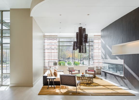 a living room with a fireplace and a large window at The Acadia at Metropolitan Park, Arlington, 22202