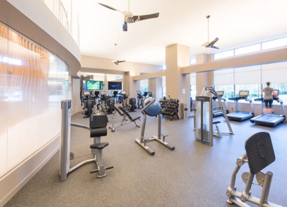 a large fitness room with treadmills and other exercise equipment at The Acadia at Metropolitan Park, Arlington