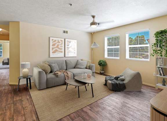 A living room with a grey couch and a rug. at Bluffs Apartments, Utah, 84065
