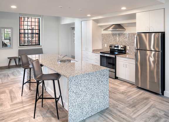 A kitchen with a granite countertop and a refrigerator.at The Residences at St. Elizabeths East, Washington District of Columbia