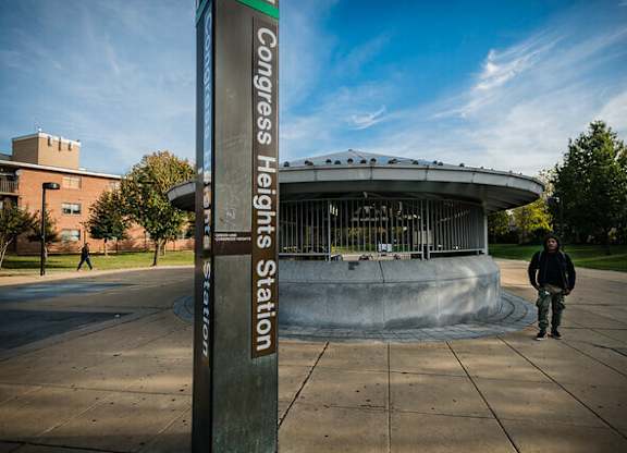 A person stands in front of a sign that says Congress Heights Station.at The Residences at St. Elizabeths East, Washington District of Columbia