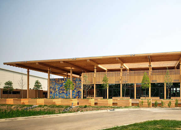 A modern building with a wooden exterior and a large mural on the side.at The Residences at St. Elizabeths East, Washington, DC 20032