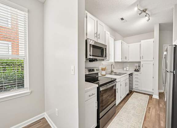 A kitchen with white cabinets and appliances.