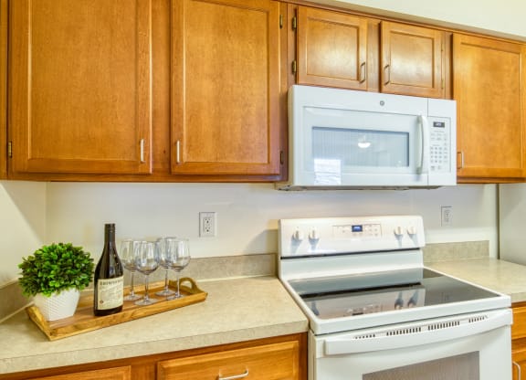a kitchen with a stove and microwave and wooden cabinets at North Market South Carroll, Frederick