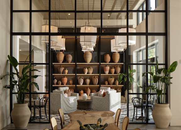 A dining room with a black and white checkered floor and a wooden table with chairs.
