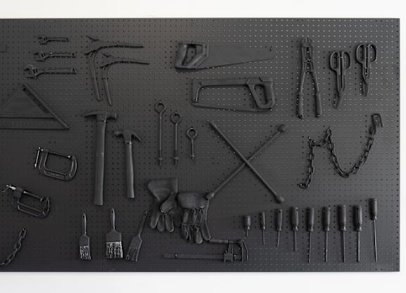 A collection of various tools is displayed on a pegboard.