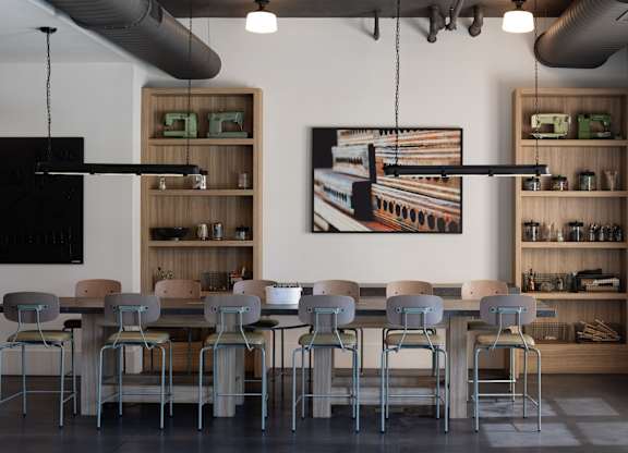 A modern dining room with a large table and chairs.
