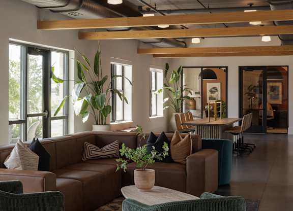 A living room with a brown couch and a green chair.