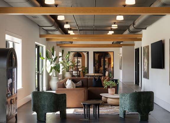 A modern living room with a large couch, two chairs, and a coffee table.