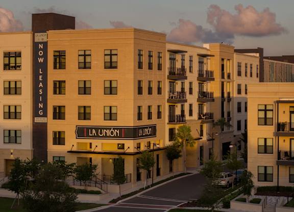 A building with the words "Now Leasing" on it is part of a residential complex.