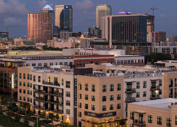 A cityscape with a mix of modern and older buildings, with the skyline visible in the distance.