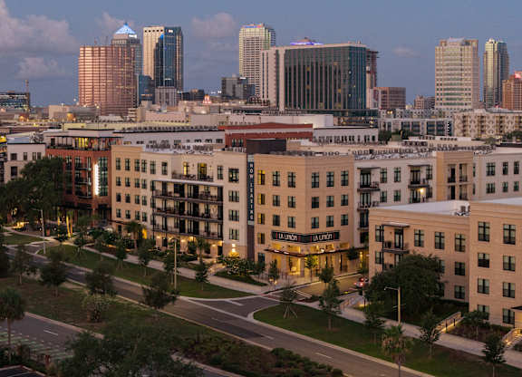 A cityscape with a large building in the foreground and several high-rise buildings in the background.