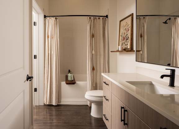 A bathroom with a toilet, sink, and shower.