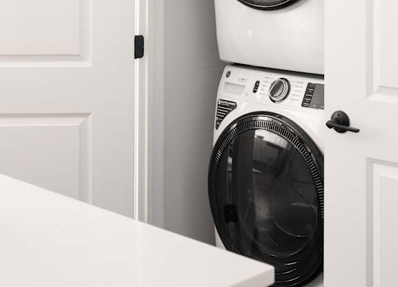 A white washing machine is in a cabinet.