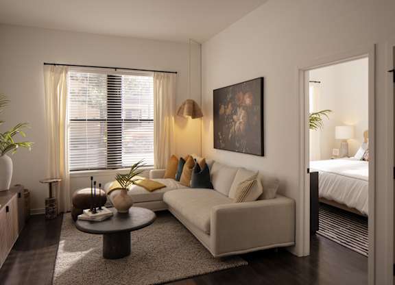 A living room with a white couch, a coffee table, and a painting on the wall.
