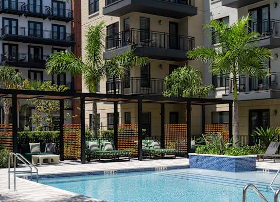 A pool surrounded by a balcony and a building.