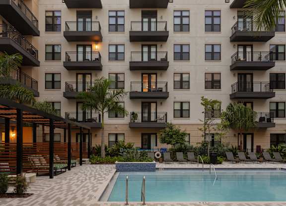 A large apartment complex with a pool in the courtyard.