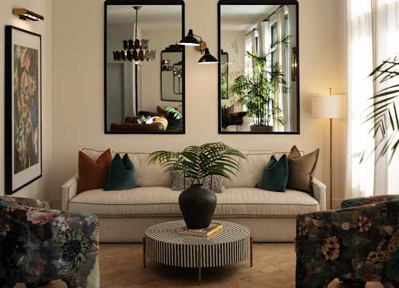 A living room with a couch, two mirrors, a coffee table, and a lamp.